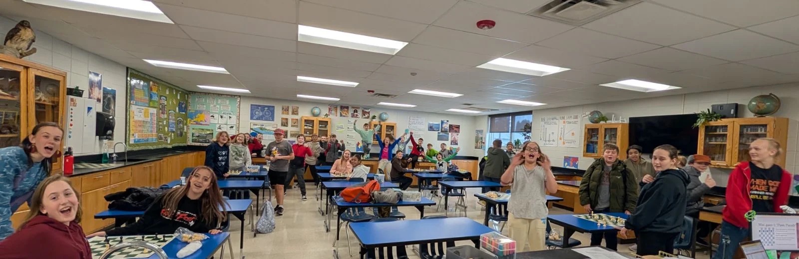 middle school students playing chess in a classroom